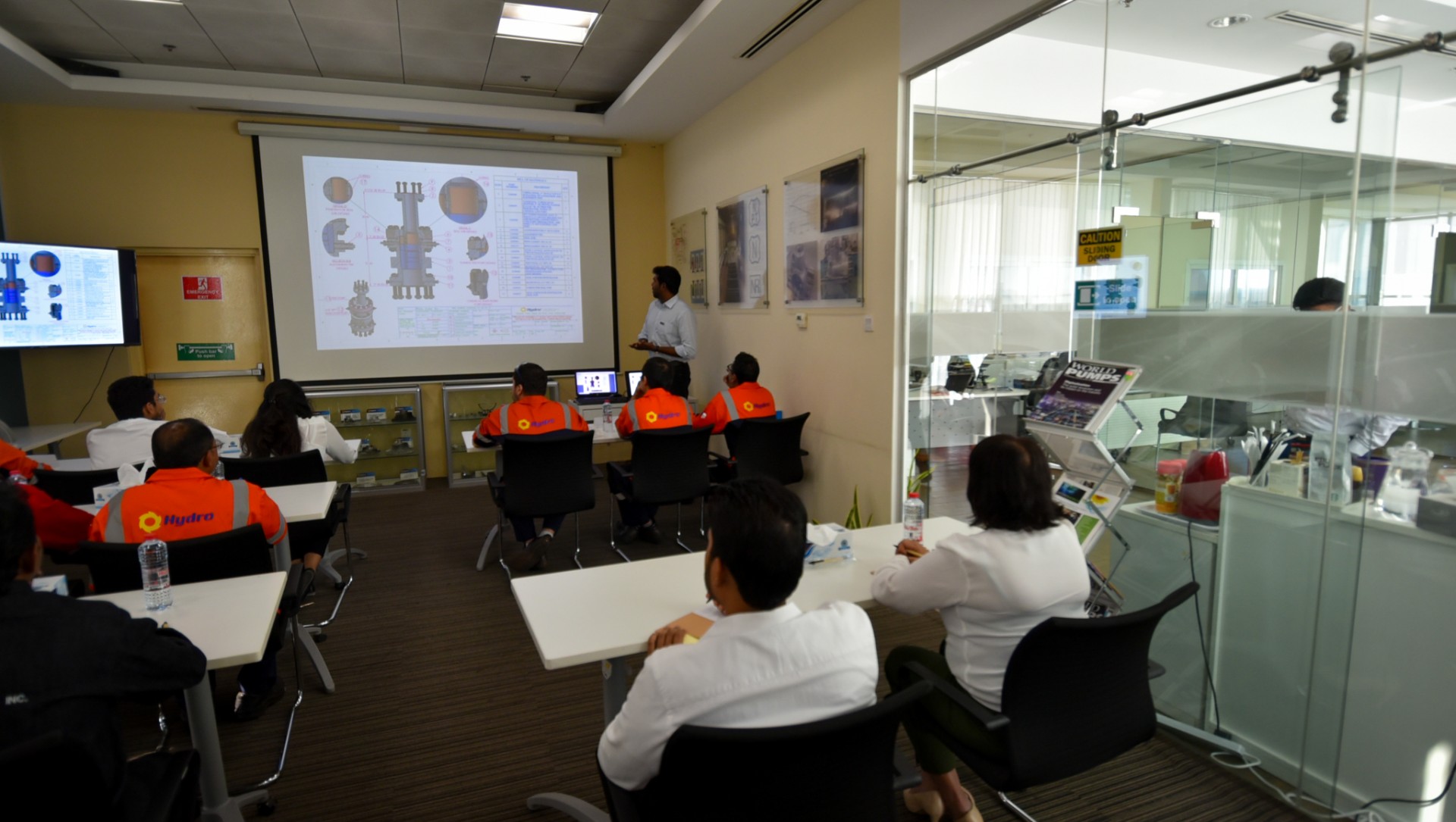 a group of people sitting at a desk in a room