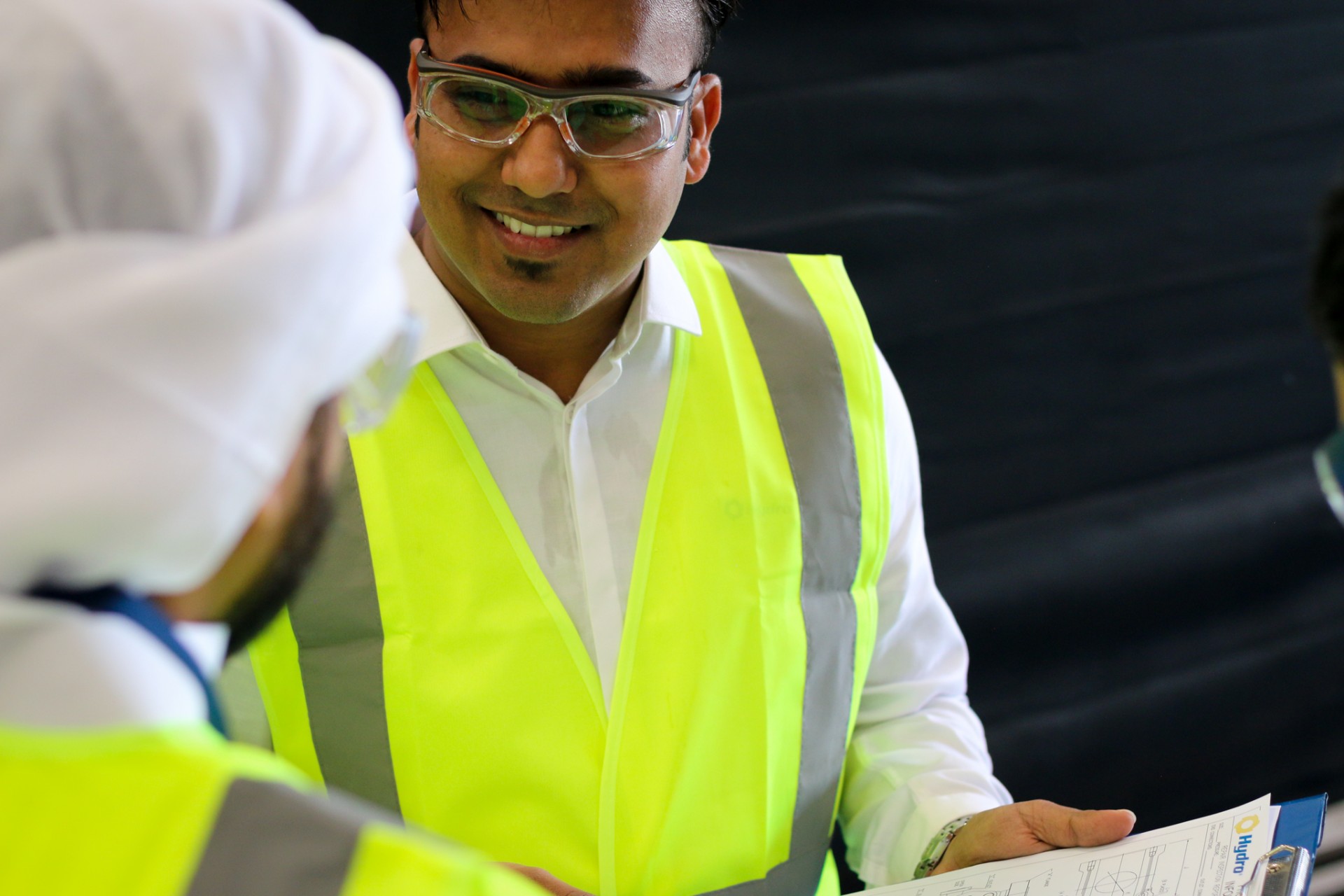a man wearing glasses and smiling at the camera