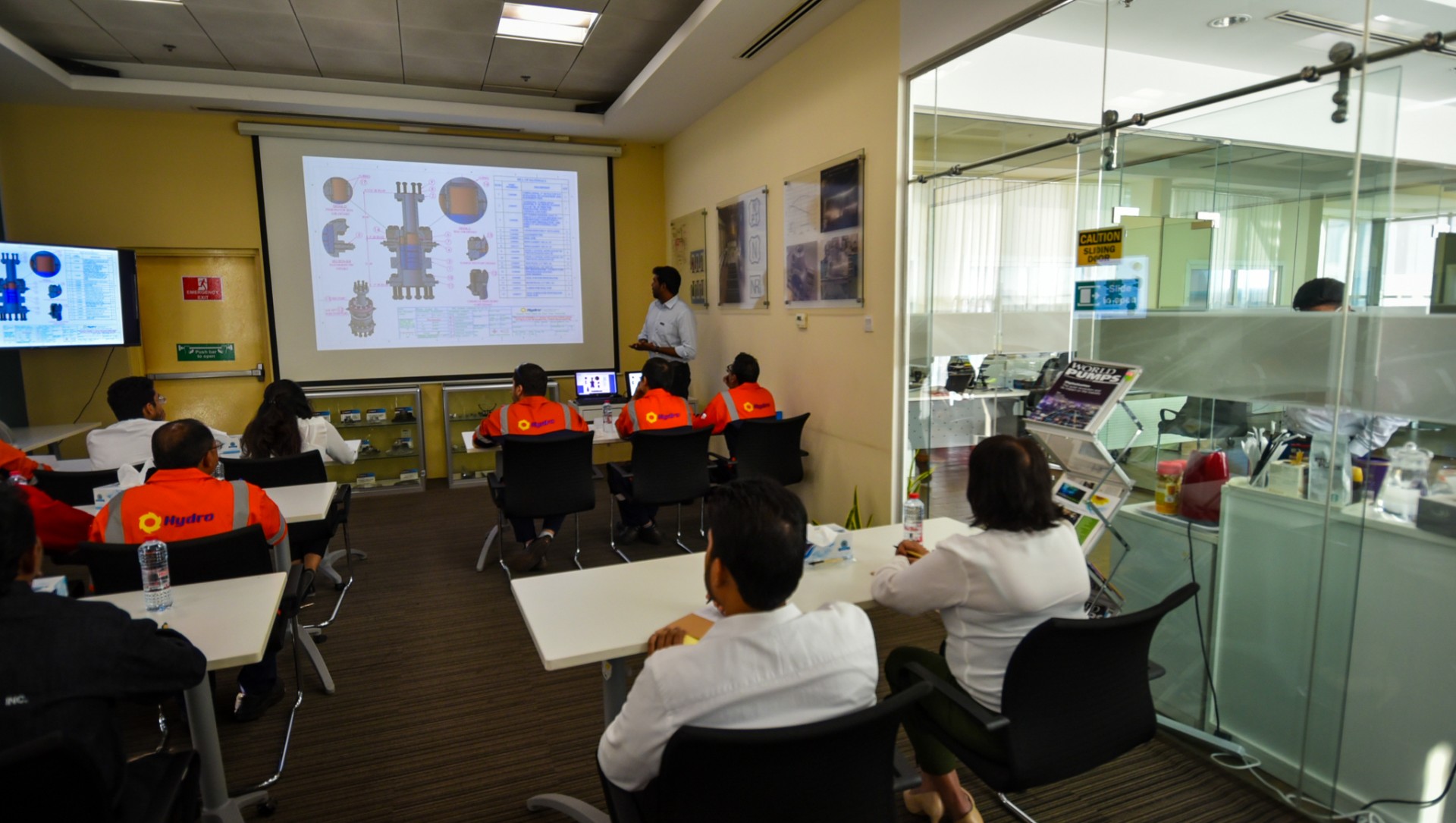 a group of people sitting at a desk in a room