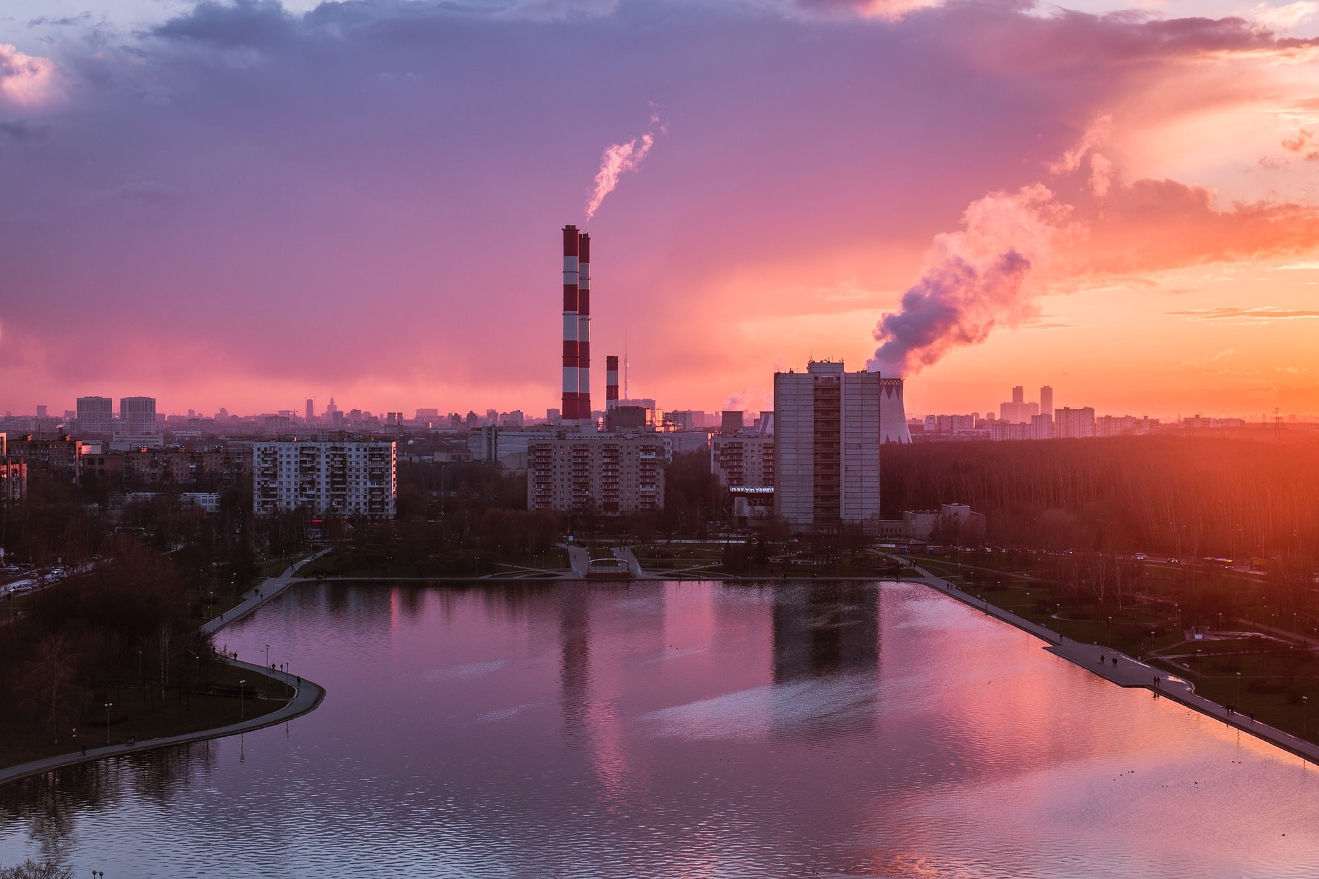 a sunset over a body of water with a city in the background